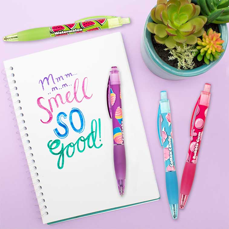 watermelon, cotton candy, cupcake, and bubble gum on a purple background with a plant in the corner and with writing on a piece of paper created using the scented pens